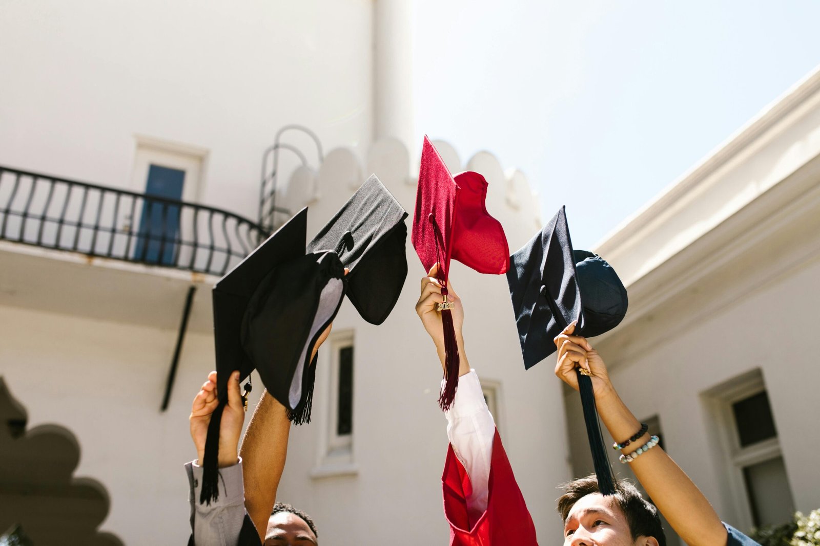 Graduates celebrate by tossing caps into air, marking joyous graduation ceremony.